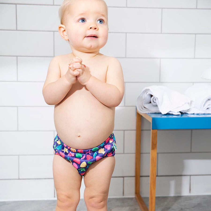 Toddler stood wearing the Totsbots mussel sea shell eco-friendly reusable baby swim pants 