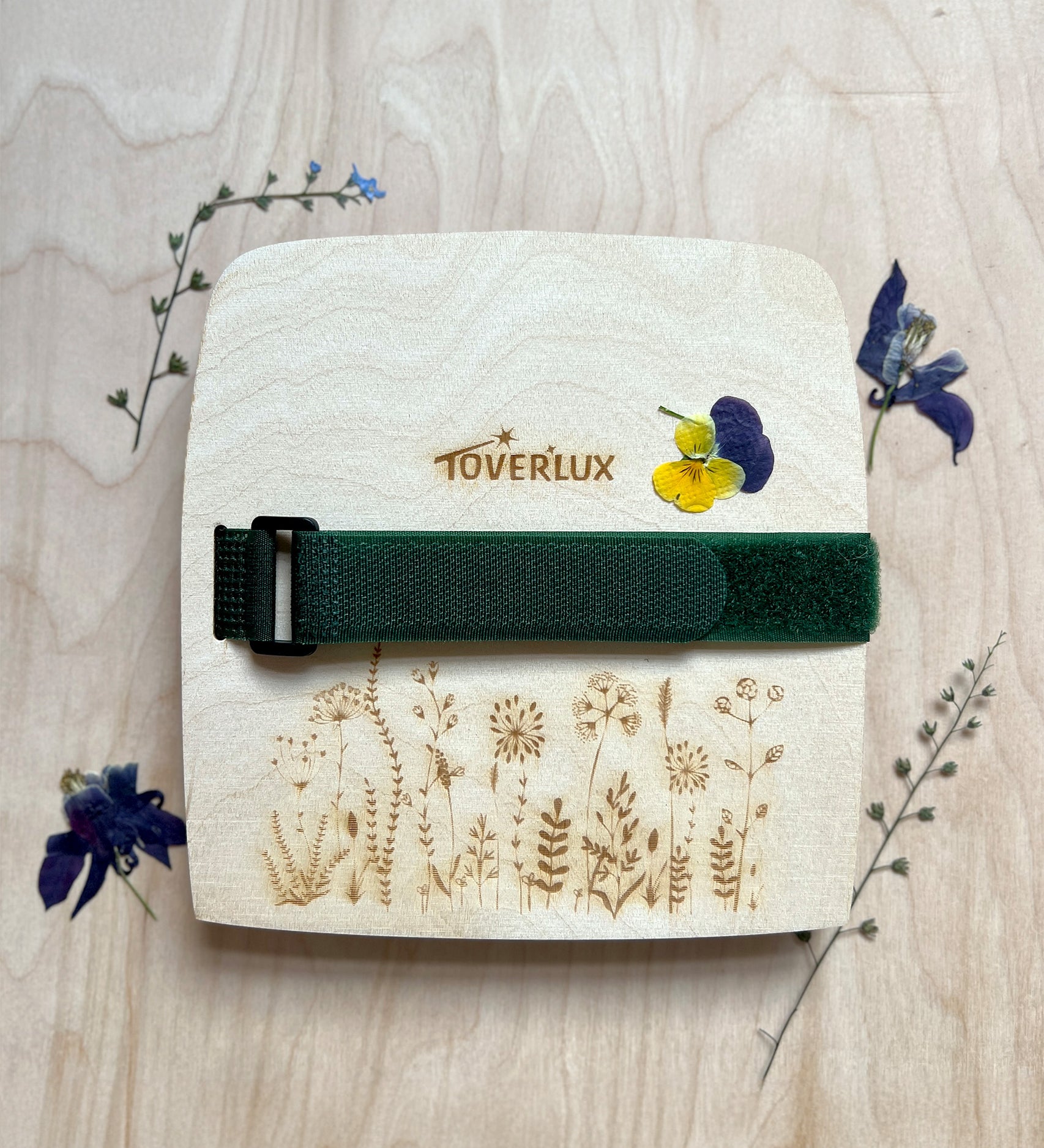 The Toverlux Wooden Flower Press, with dried pressed flowers surrounding the press, on a wooden background