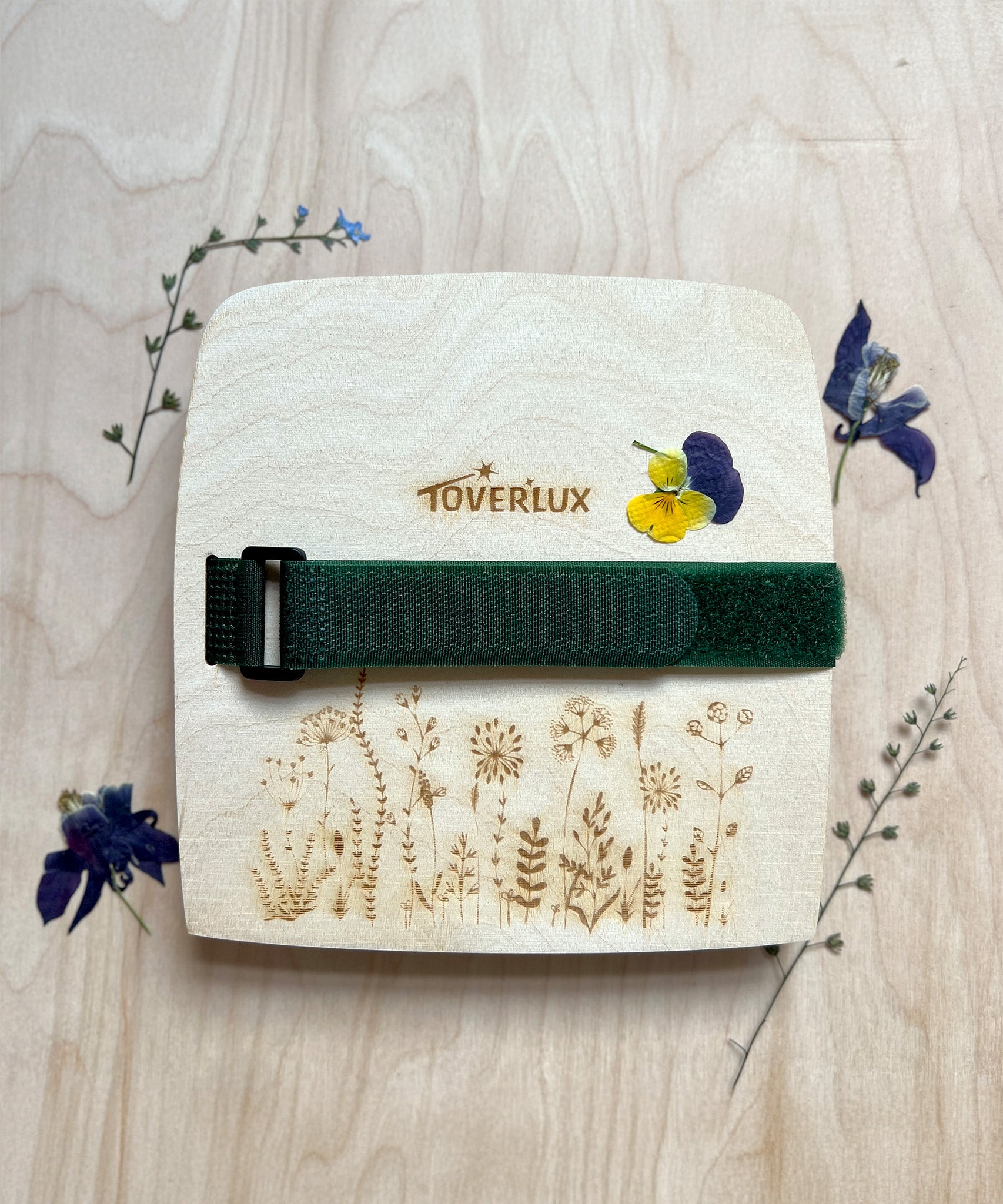 The Toverlux Wooden Flower Press, with dried pressed flowers surrounding the press, on a wooden background