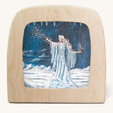 Toverlux Magic Lamp with a Snow Queen silhouette By Nathaniel Santa Cruz. A blue chalk style illustration of a snow queen with a white magical trails standing on a snow covered ground.