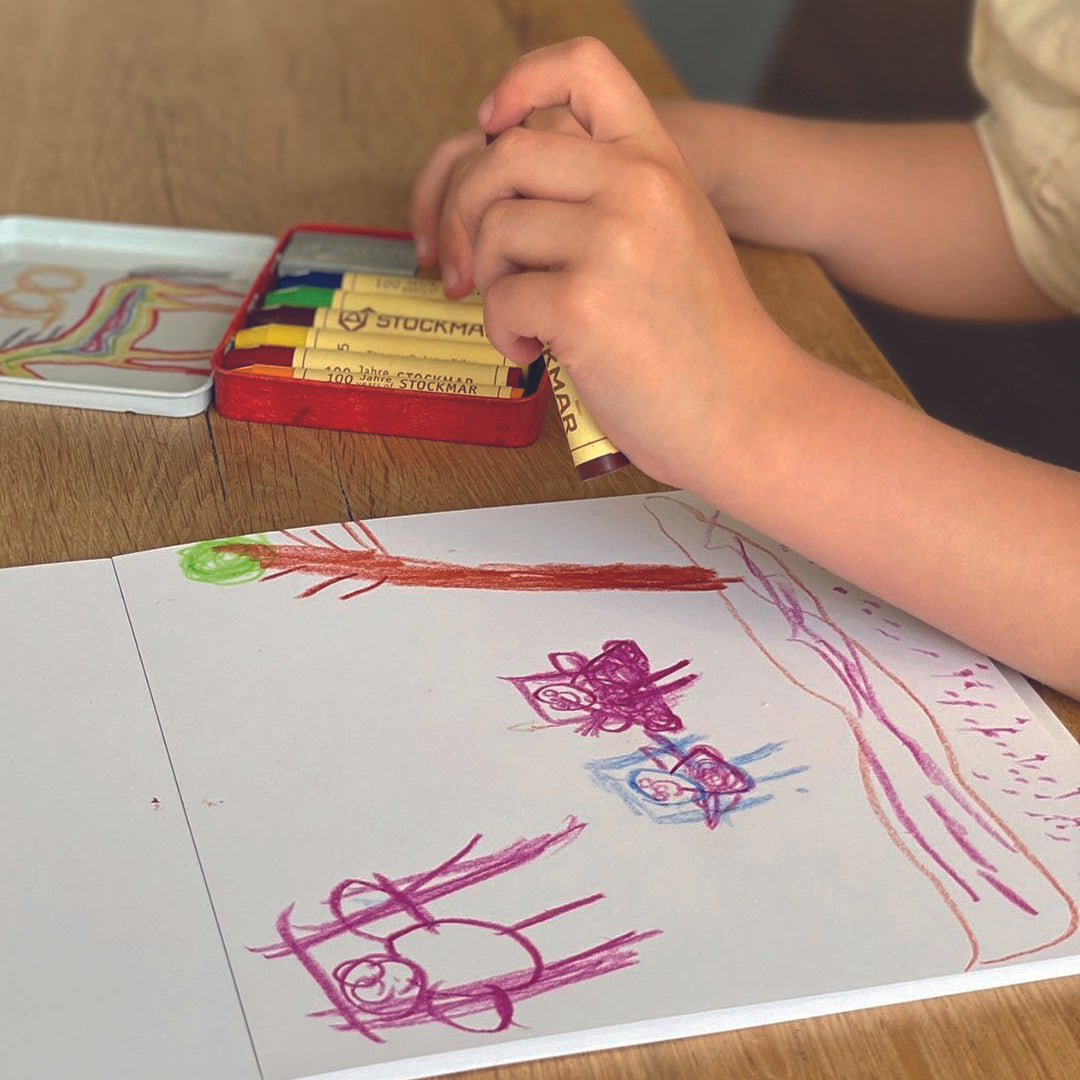 A child drawing with the Stockmar Crayons on the Toverlux X Stockmar paper set