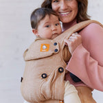 Close up of woman carrying a baby in the Tula explore mesa linen baby carrier