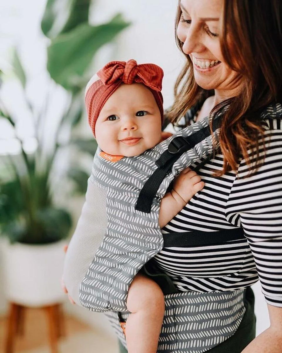 Close up of a baby in the Tula soft free to grow baby carrier in the coast beyond print