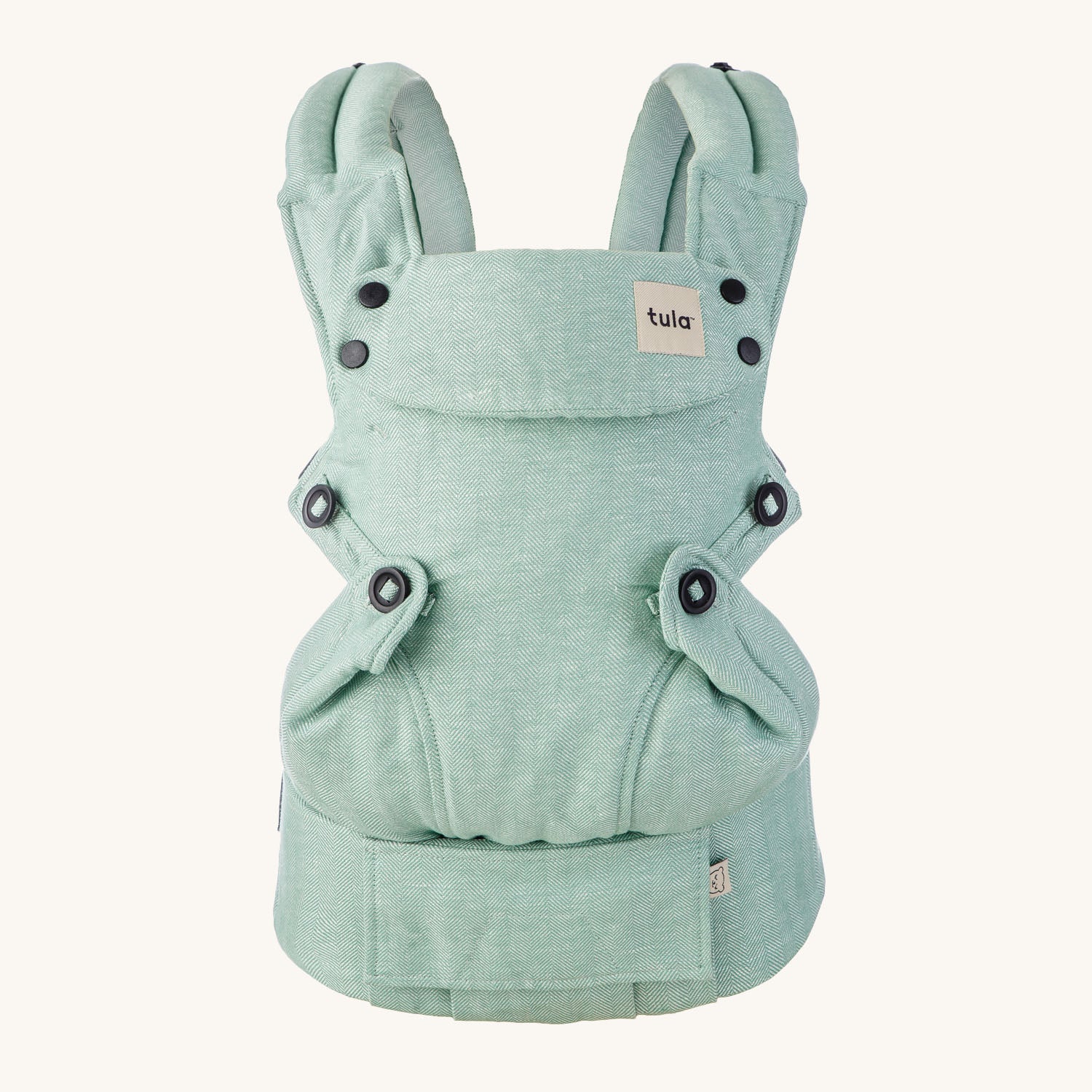 Tula Ergonomic Multi-Position Explore Baby Carrier 7-45lbs in Eucalyptus on a cream background