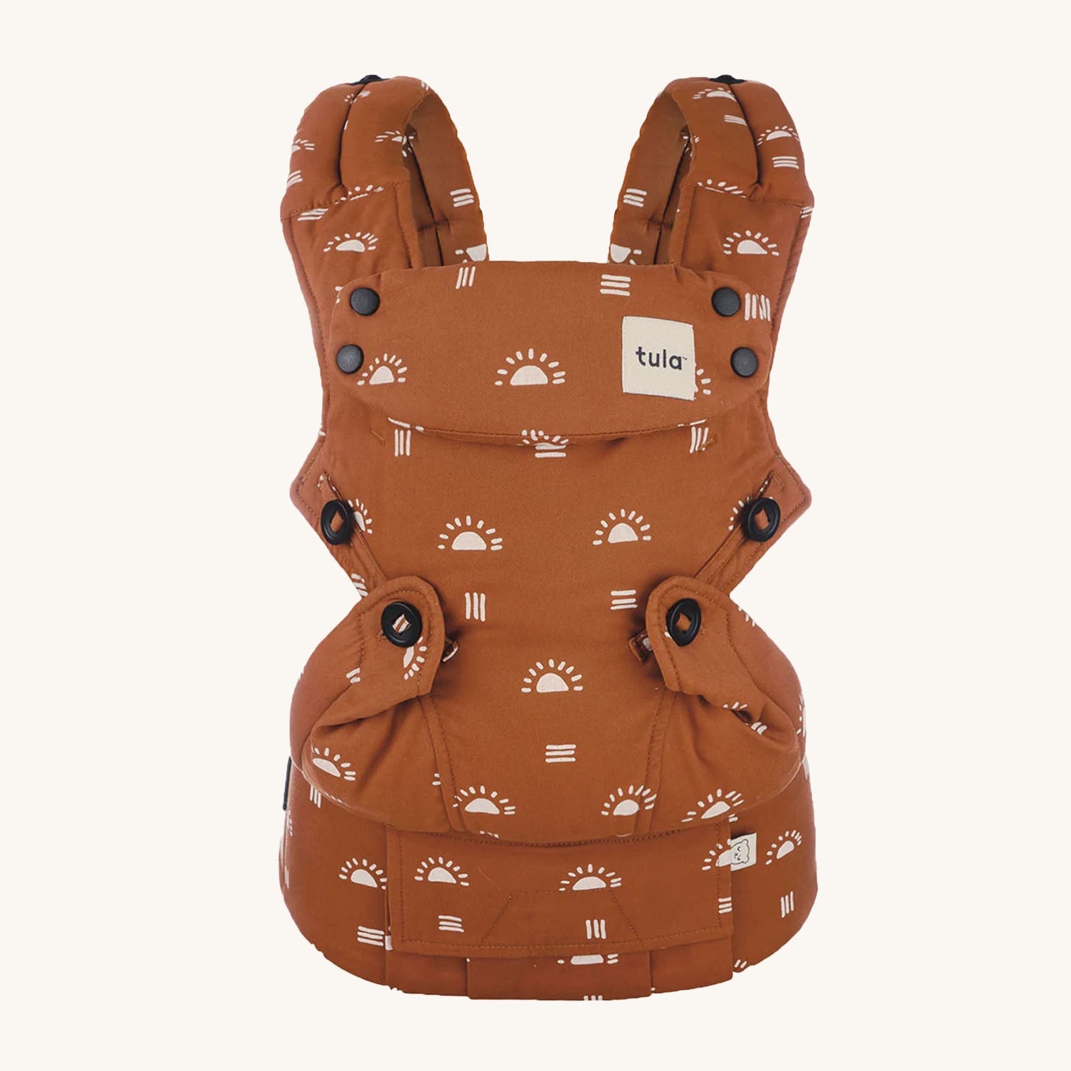 Tula Ergonomic Multi-Position Explore Baby Carrier 7-45lbs in Sedonia. Carrier is a burnt orange colour and playful sun and stripe patterns