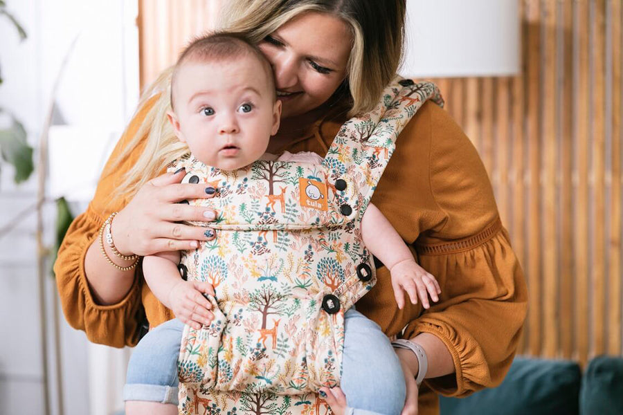 Close up of woman holding a baby in a Tula explore charmed baby carrier