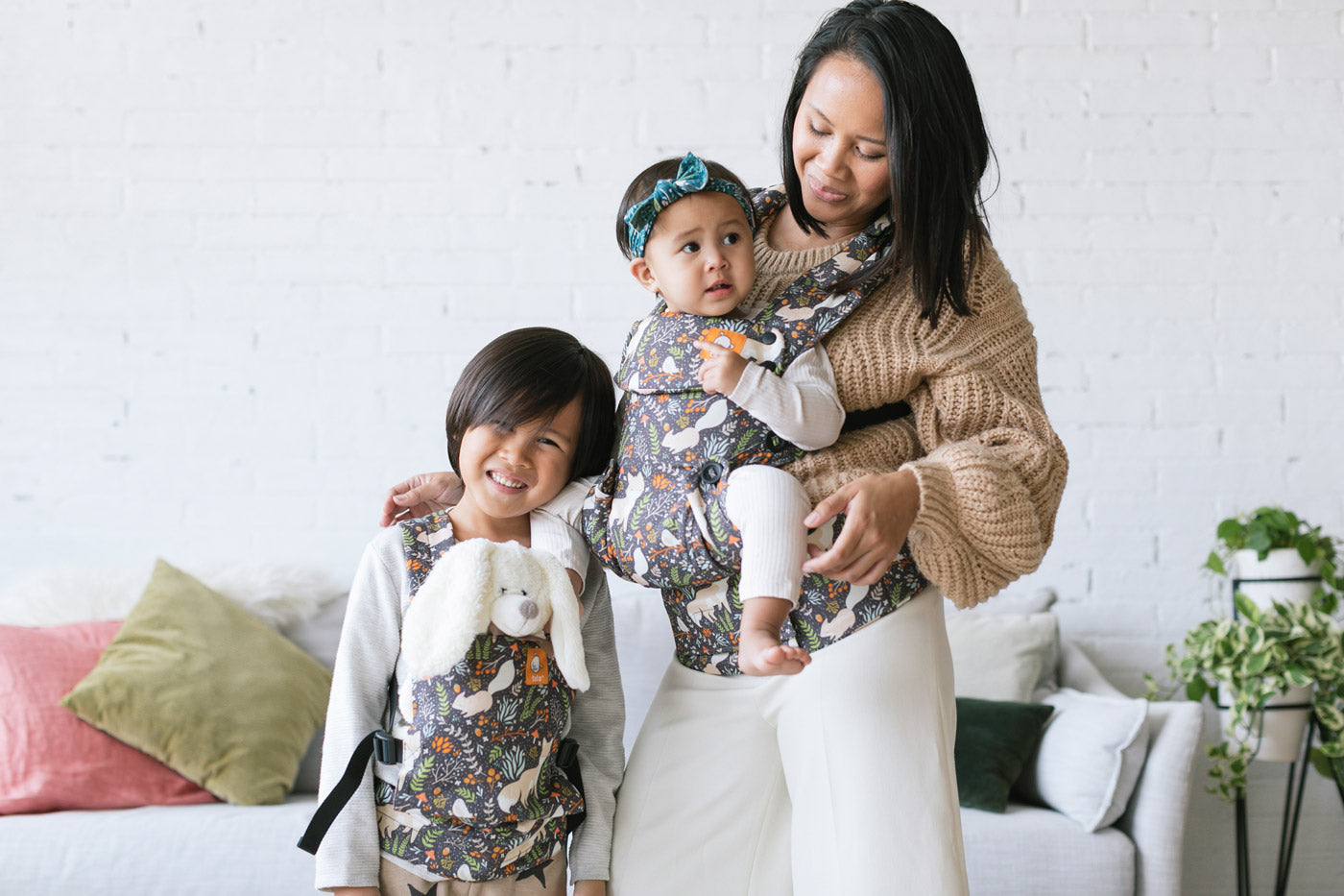 Woman stood carrying a young child in a Tula explore baby carrier