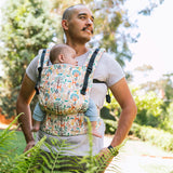 Close up of man in a garden with a baby inside a Tula soft structured FTG baby carrier