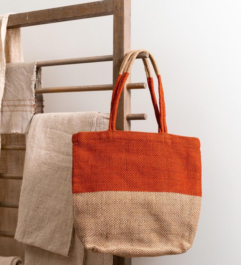 Turtle Bags eco-friendly orange block colour tote bag hanging on a wooden hook in front of a white wall