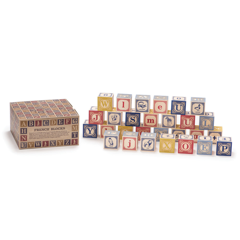 Uncle Goose plastic free French block toys stacked in a pile on a white background next to their cardboard box