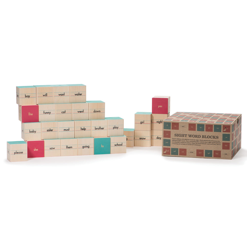 Uncle Goose plastic free wooden sight word block toys stacked in a pile on a white background next to their cardboard box