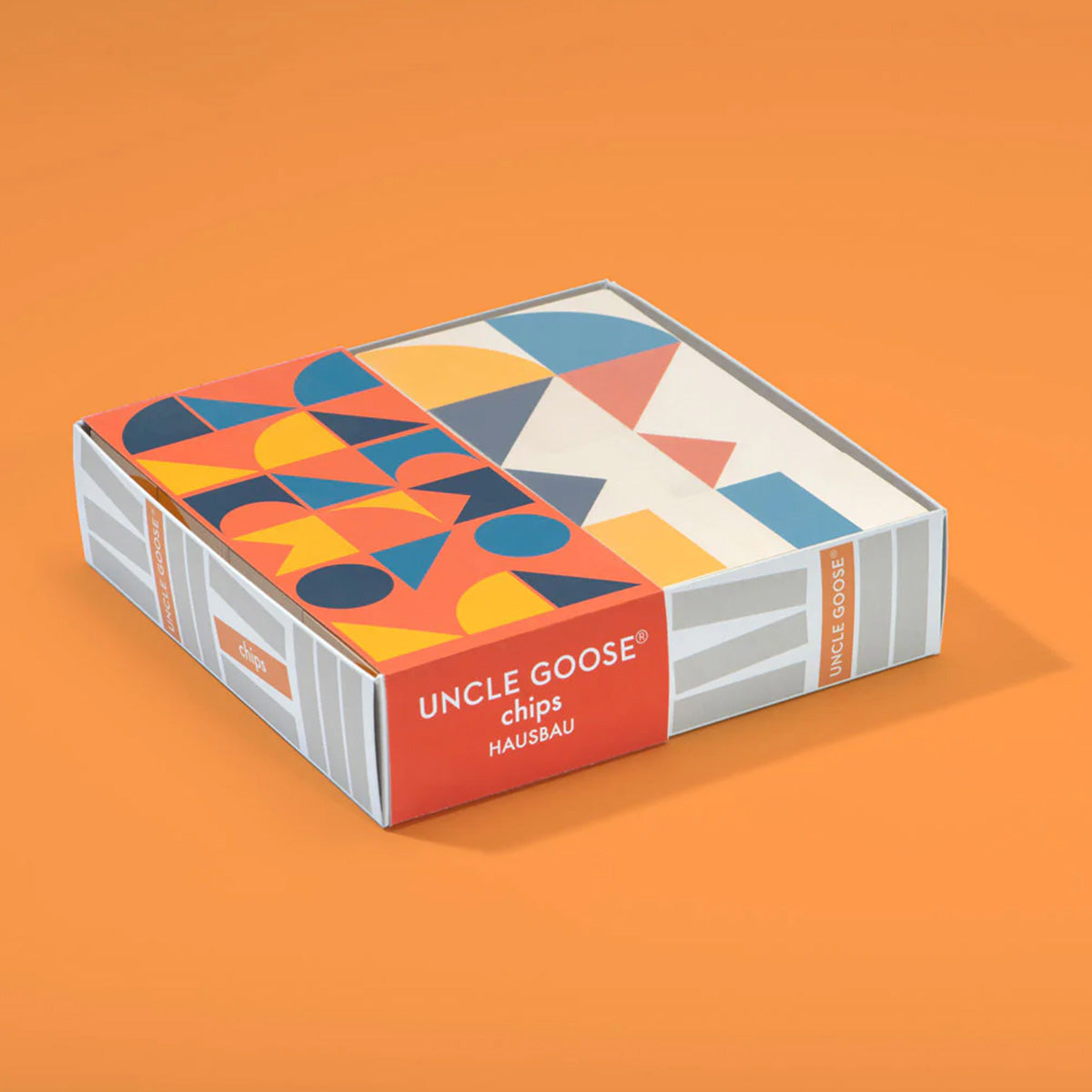 Box of Uncle Goose eco-friendly wooden Hausbau chips laid on an orange background