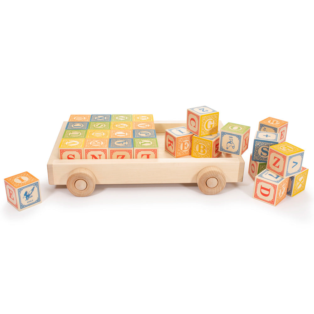 Uncle Goose eco-friendly wooden alphabet blocks on top of the wooden block pull wagon on a white background