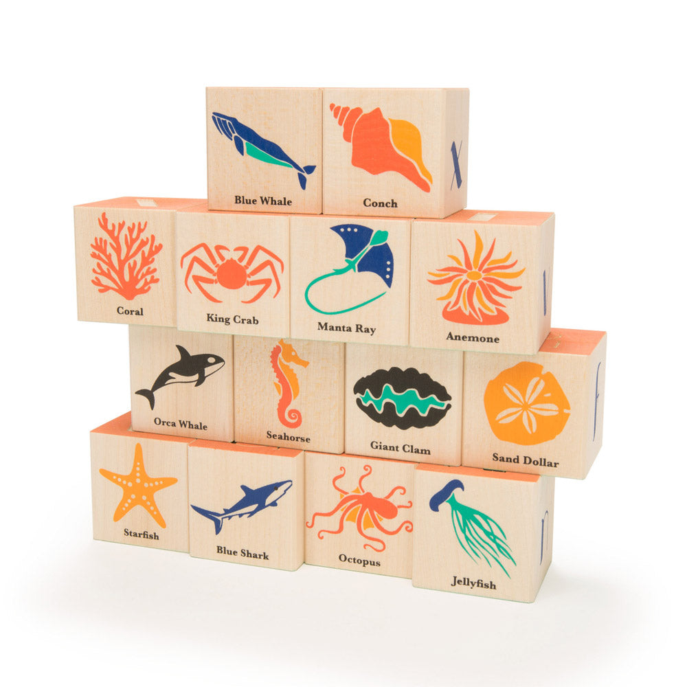 Uncle goose handmade wooden ocean building toy blocks stacked in a pile on a white background