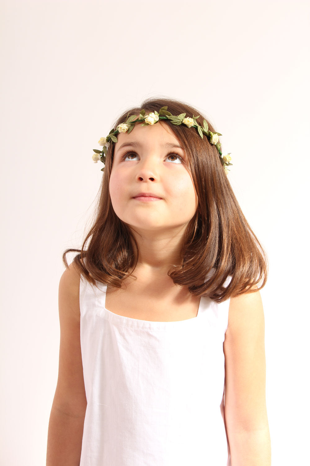 Child wearing the vah cream flower crown and a white dress