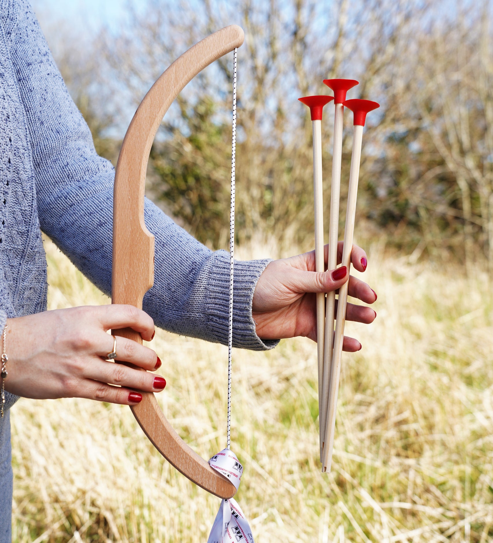 A close up of a child's hand folding the bow and arrows from the Vah Easy Aim Bow with Safety Arrows Set.