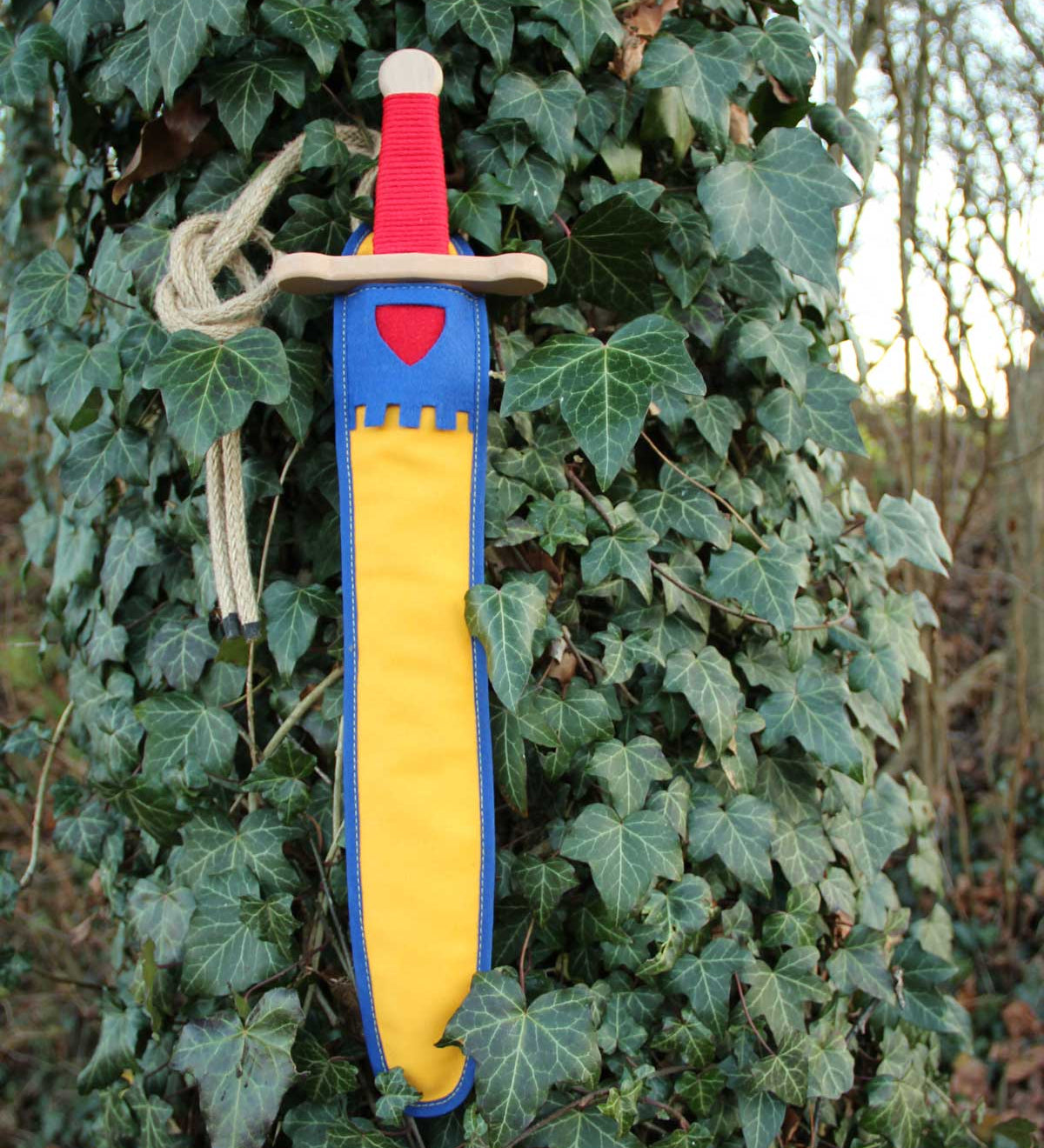 Vah Landsknecht Yellow & Blue Wooden Sword Set pictured on an ivy covered tree