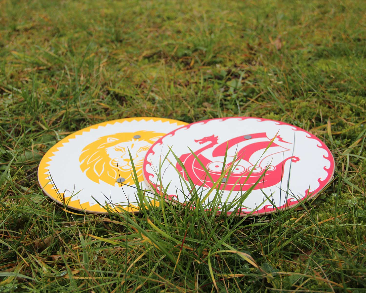 Vah Leopold Lion Mini Wooden Shield pictured on grass with the viking snorre shield next to it