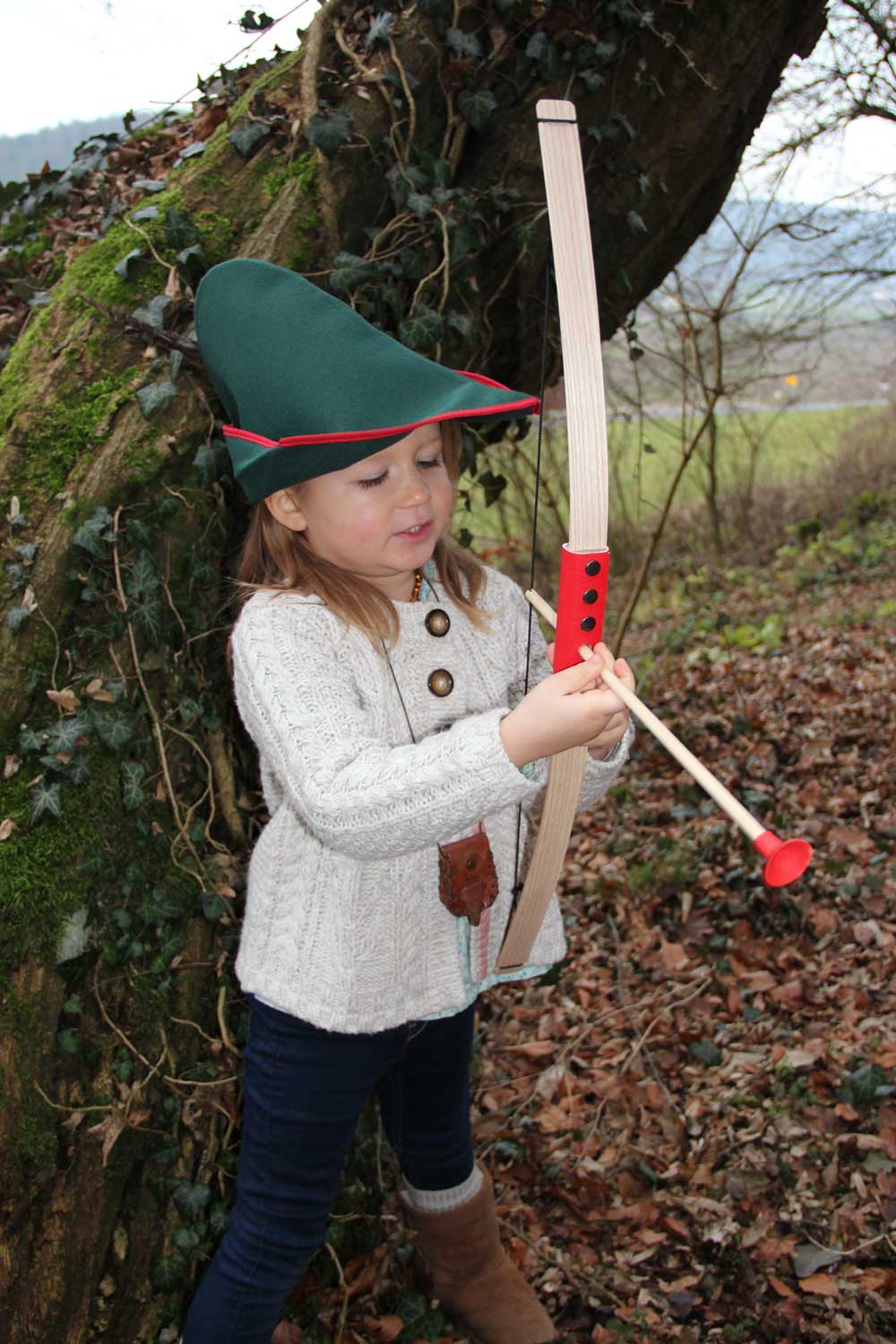 Child outdoors playing with the Vah Mini Wooden Bow with Safety Arrows