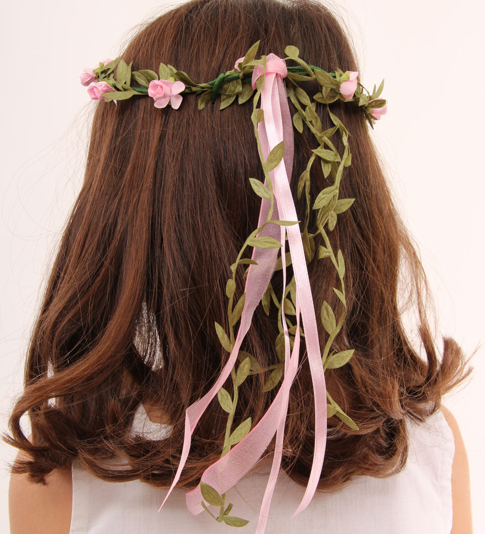 child with brown coloured hair wearing a Vah pink flower crown. View of the back of the child's head