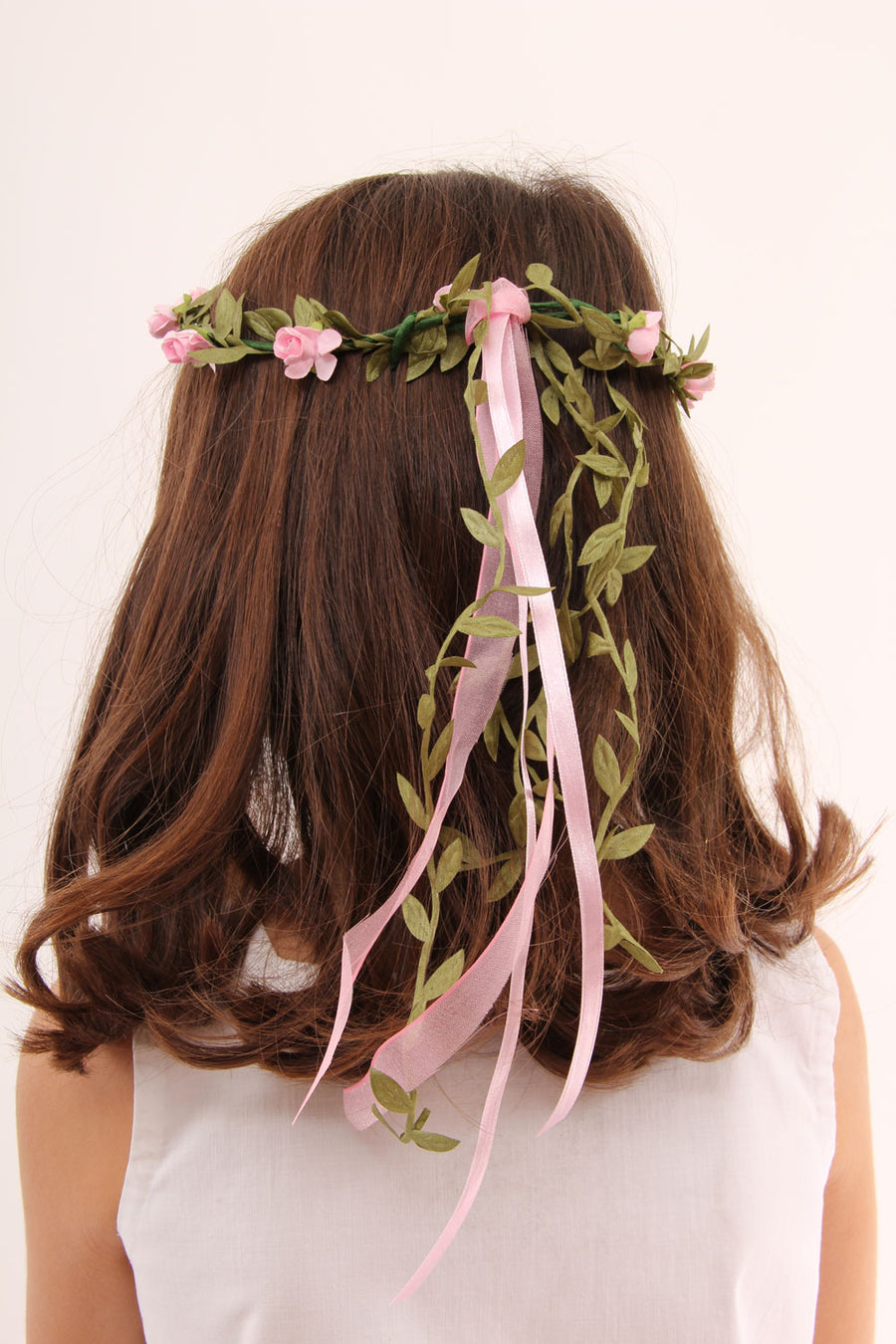 child with brown coloured hair wearing a Vah pink flower crown. View of the back of the child's head