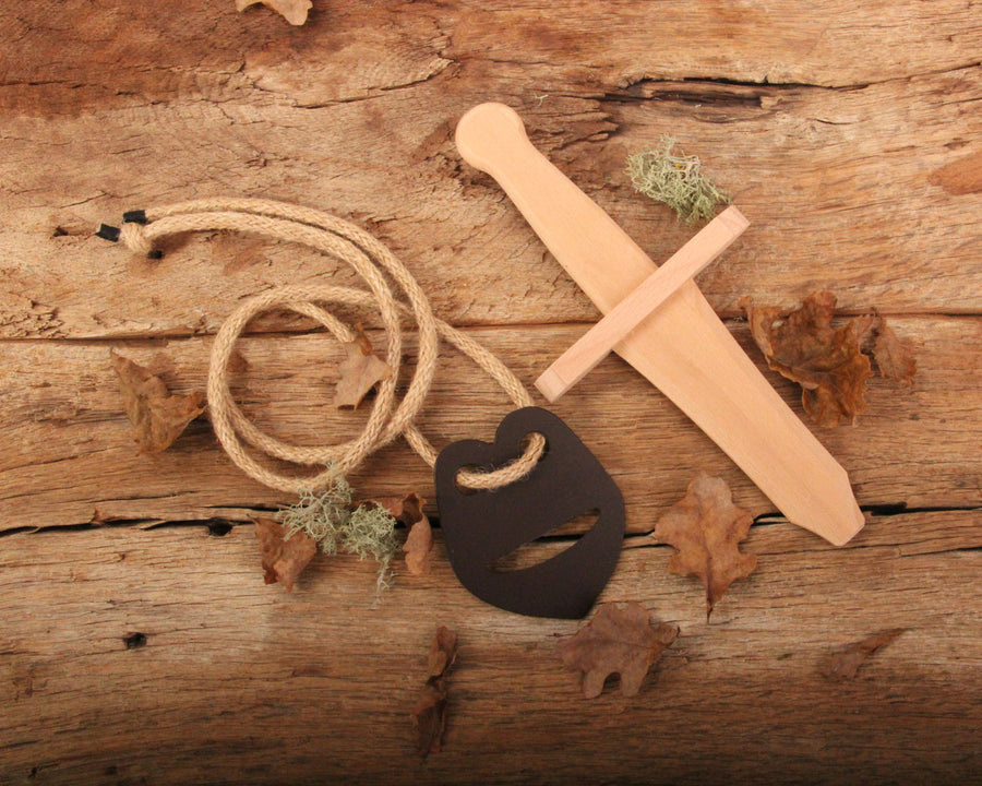 Vah Recycled Leather Sword Hanger pictured on a wooden surface next to small sword