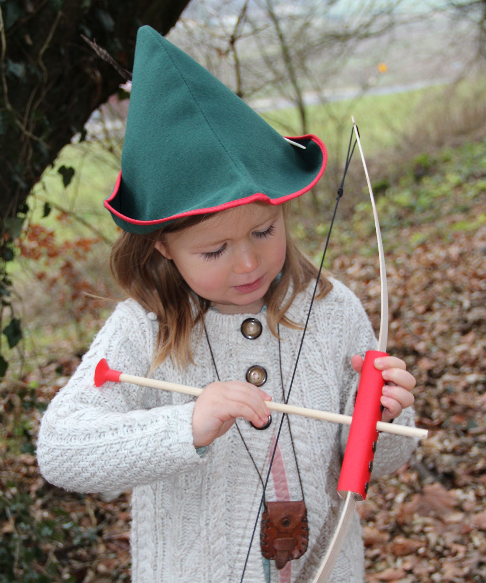 A child wearing a VAH robin hood hat playing with a bow and arrow.