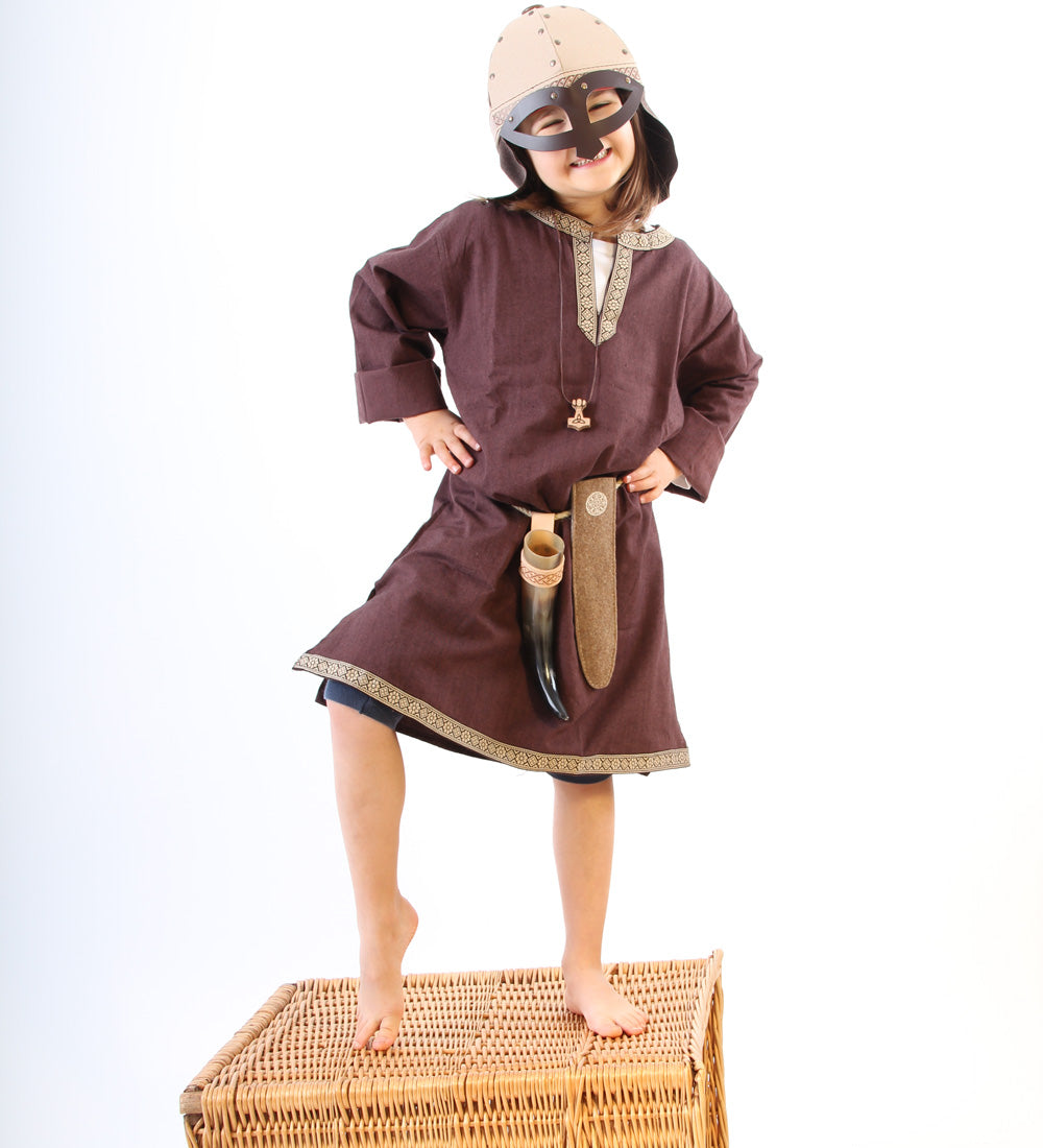 Child wearing a Vah Wiki Viking Helmet with Glasses stood on a wicker hamper