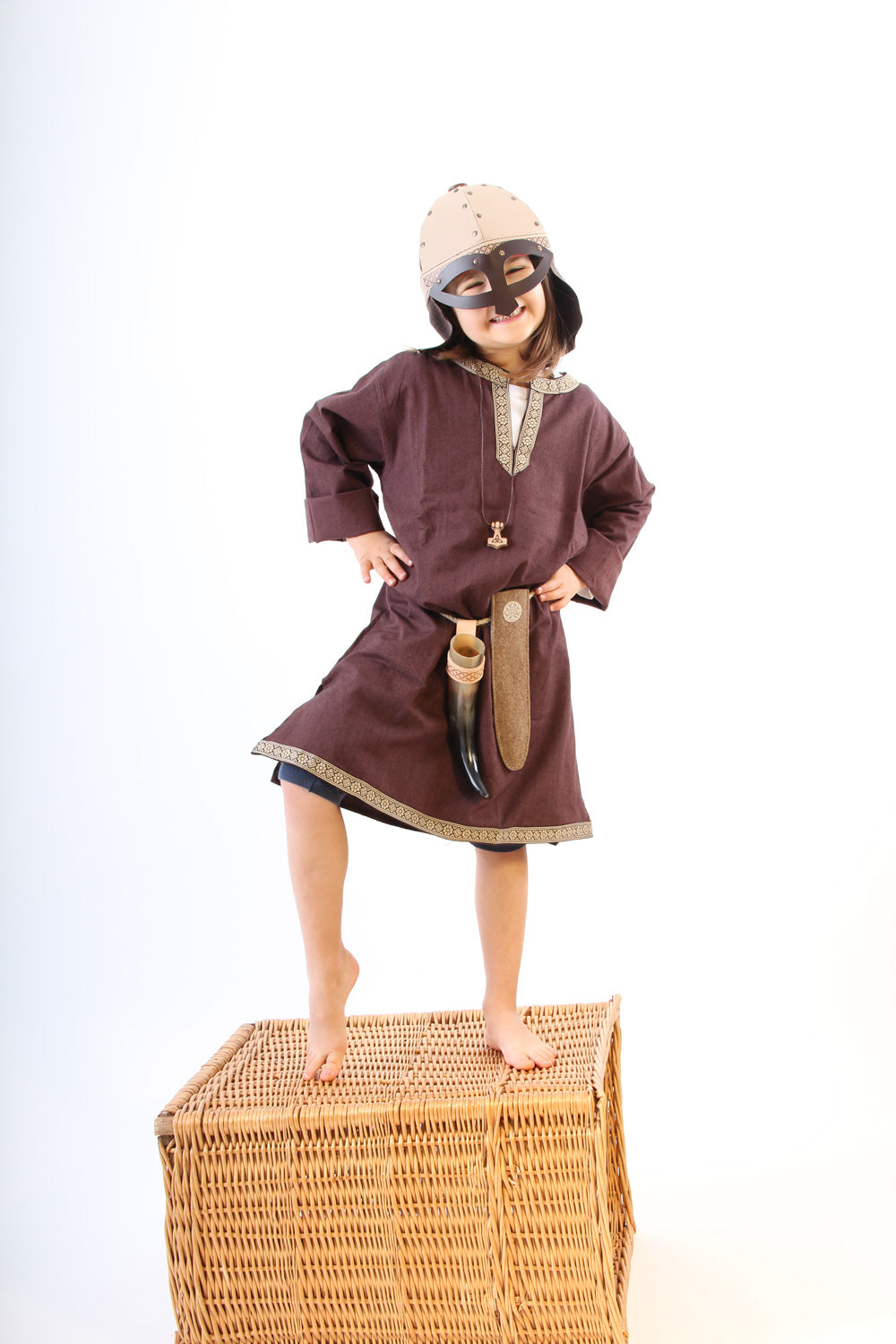 Child wearing a Vah Wiki Viking Helmet with Glasses stood on a wicker hamper