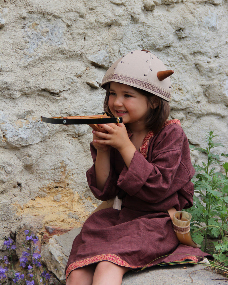 Child smiling playing with the Vah Junior Wooden Bow toy