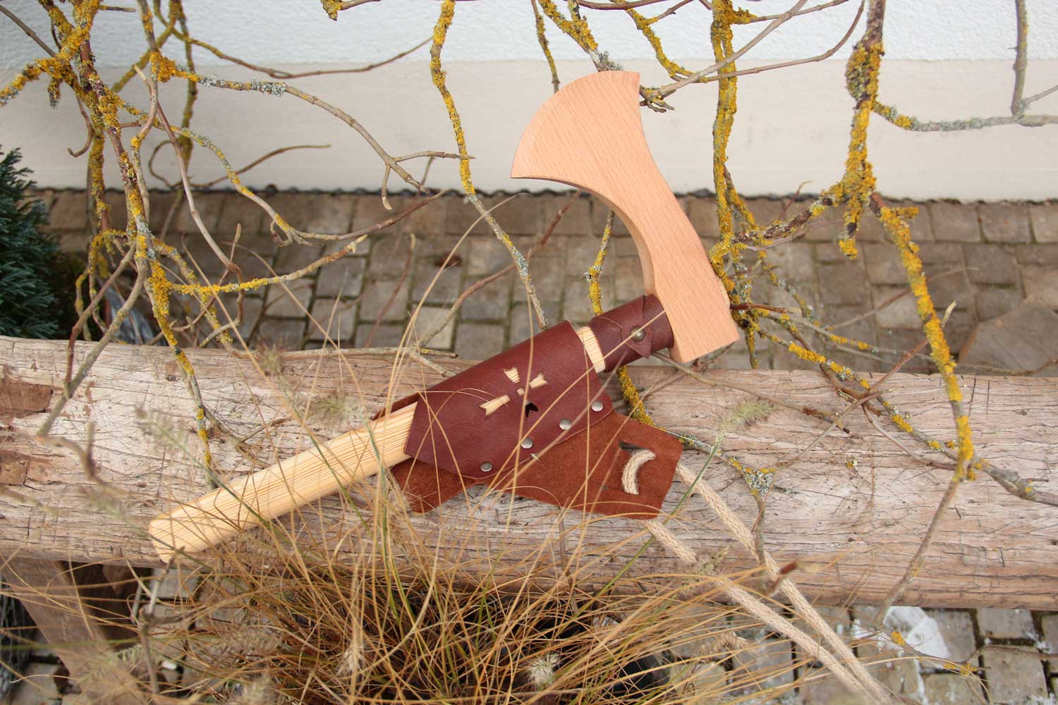 vah wooden battle axe placed on a wooden bench outdoors