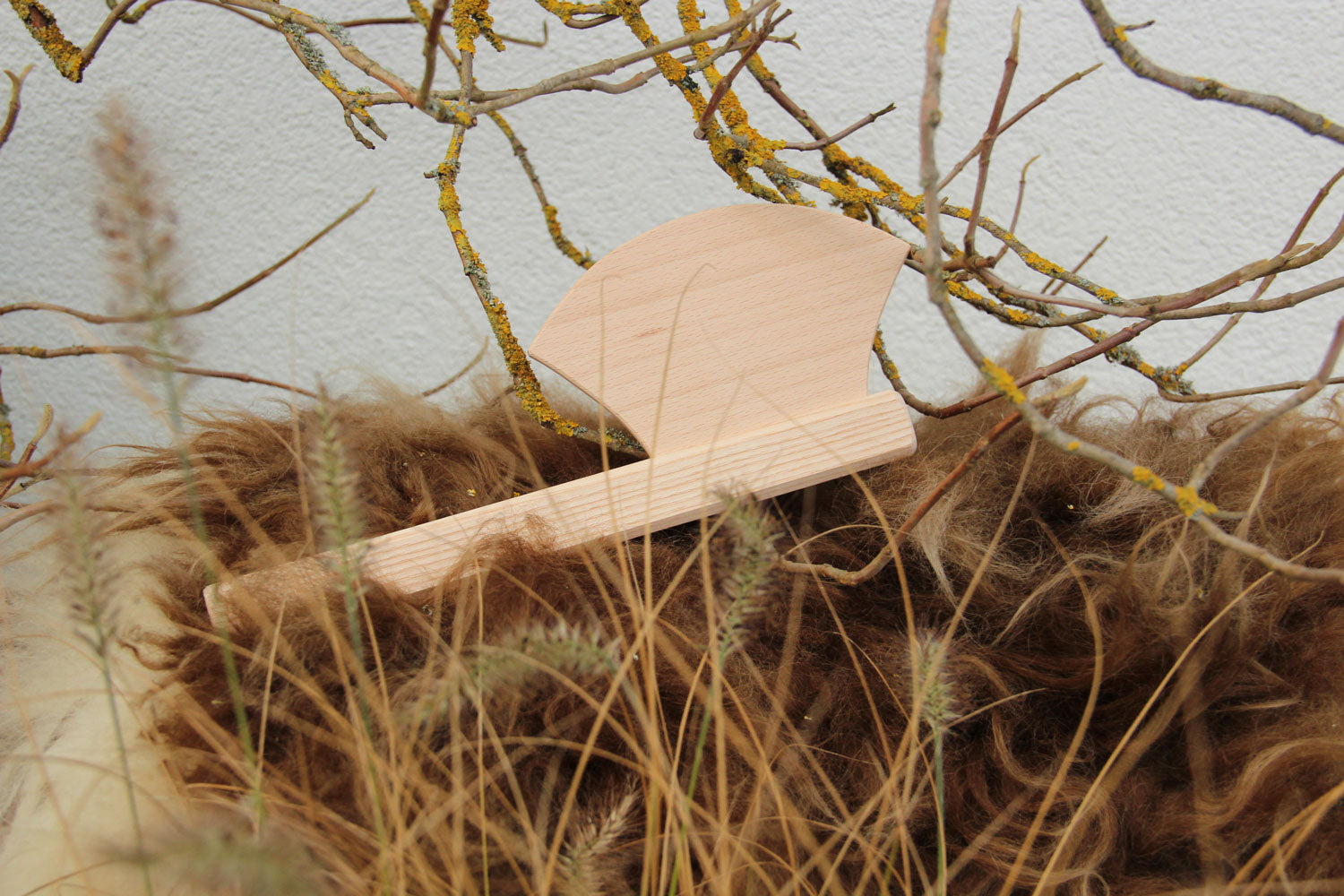 Vah wooden mini axe toy placed among branches