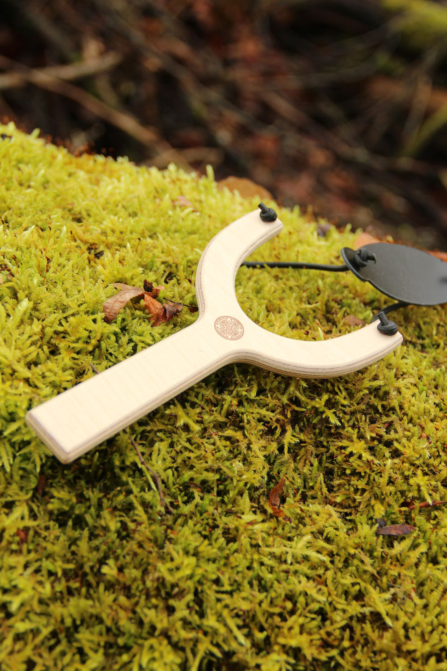 vah wooden sling shot placed on moss outdoors