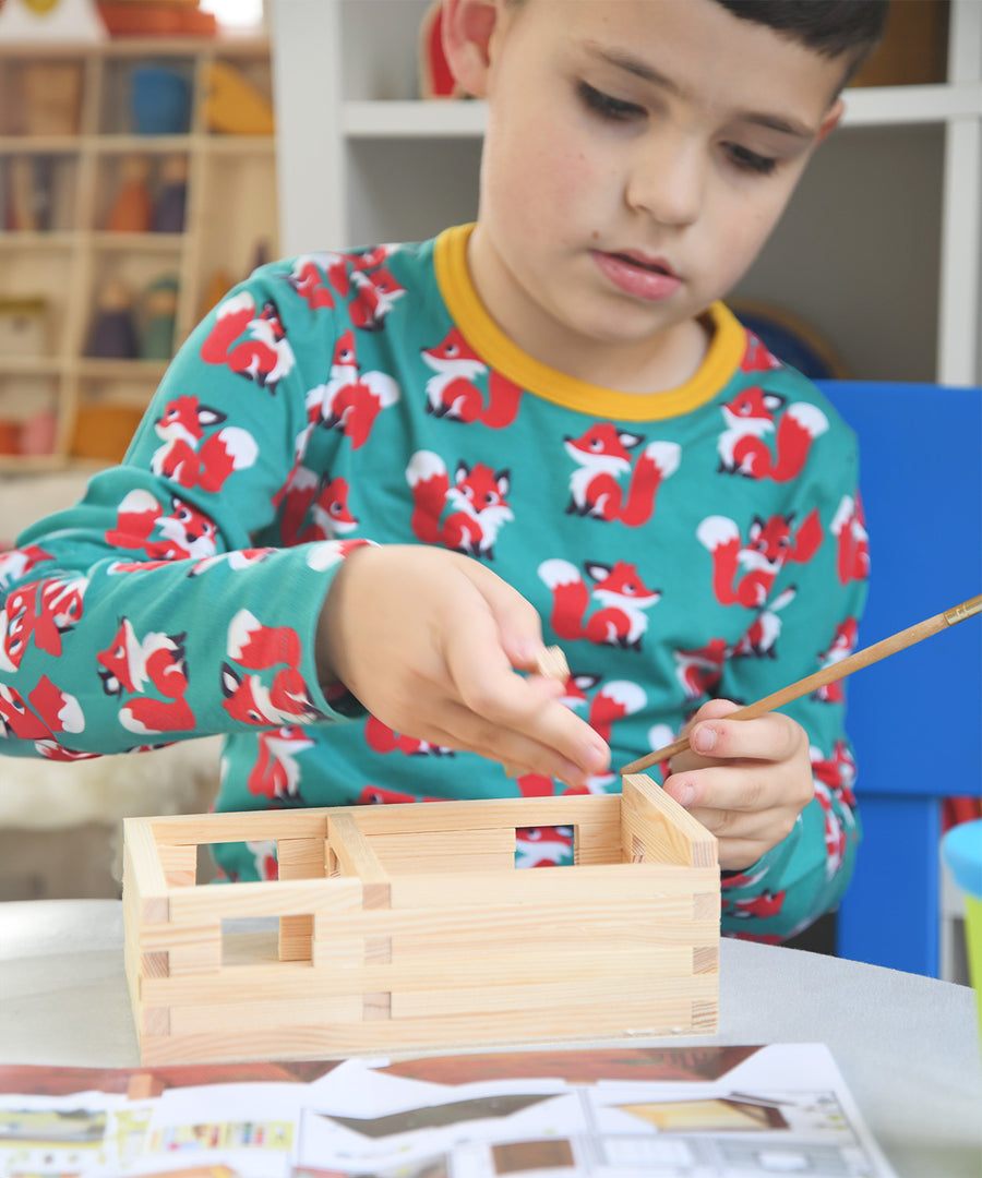 A child patiently and carefully building the WALACHIA house kit