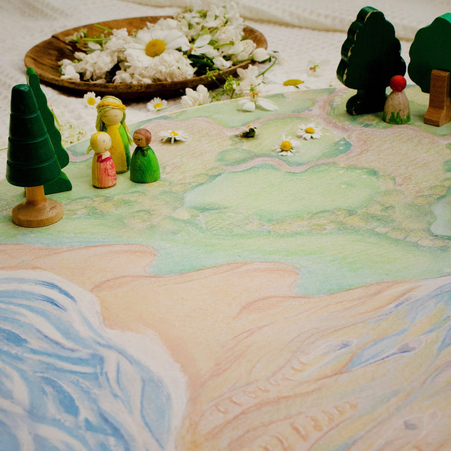 Close up of some wooden toys and daisys laid out on the Waldorf family handmade wooden farm play board