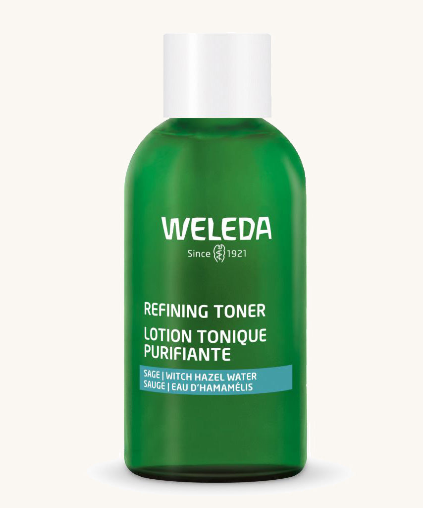 A green Weleda bottle for the refining toner on a cream background