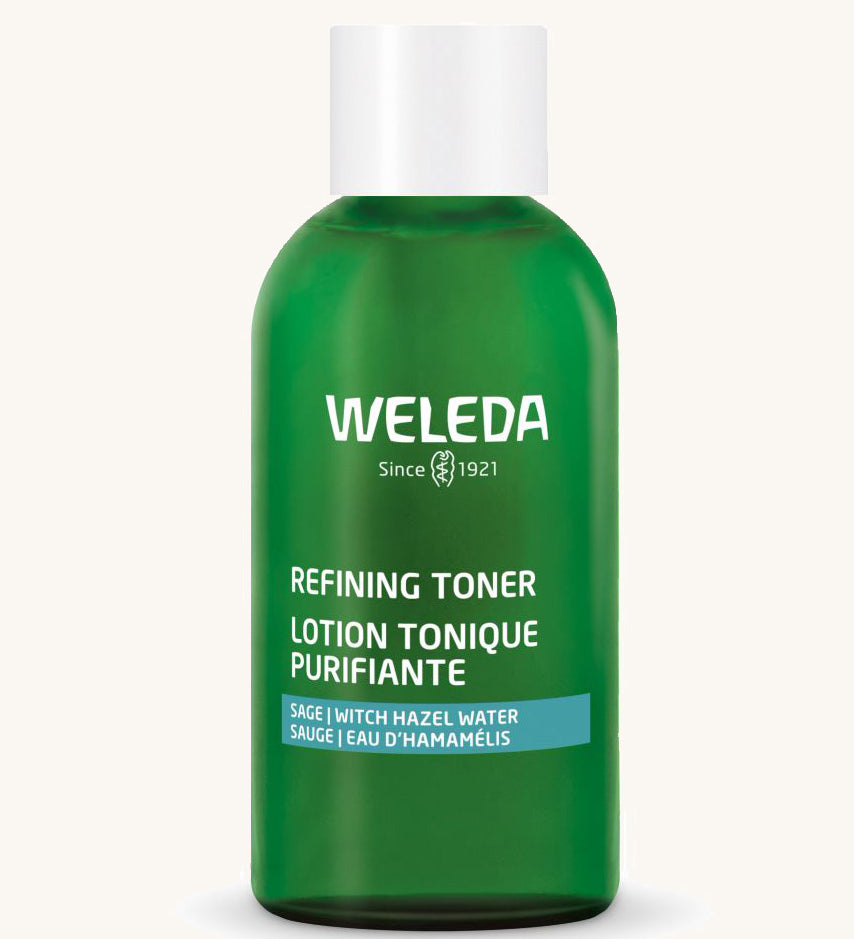 A green Weleda bottle for the refining toner on a cream background