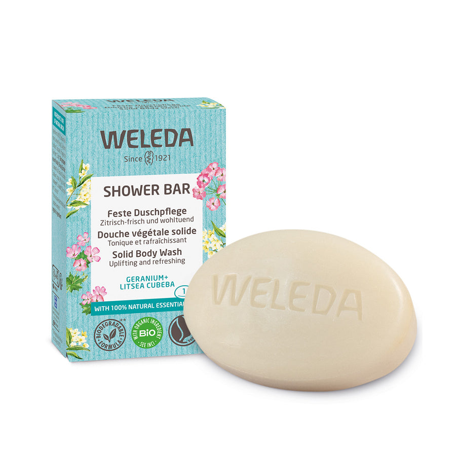 Weleda 75g solid shower body wash bar in the geranium and litsea cubeba scent next to its cardboard box on a white background