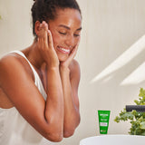 A close up photo of a person washing their face with the Weleda Nourishing face balm