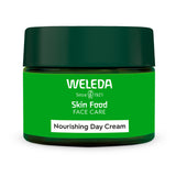 A close up photo of a person using the Weleda nourishing day cream on their skin