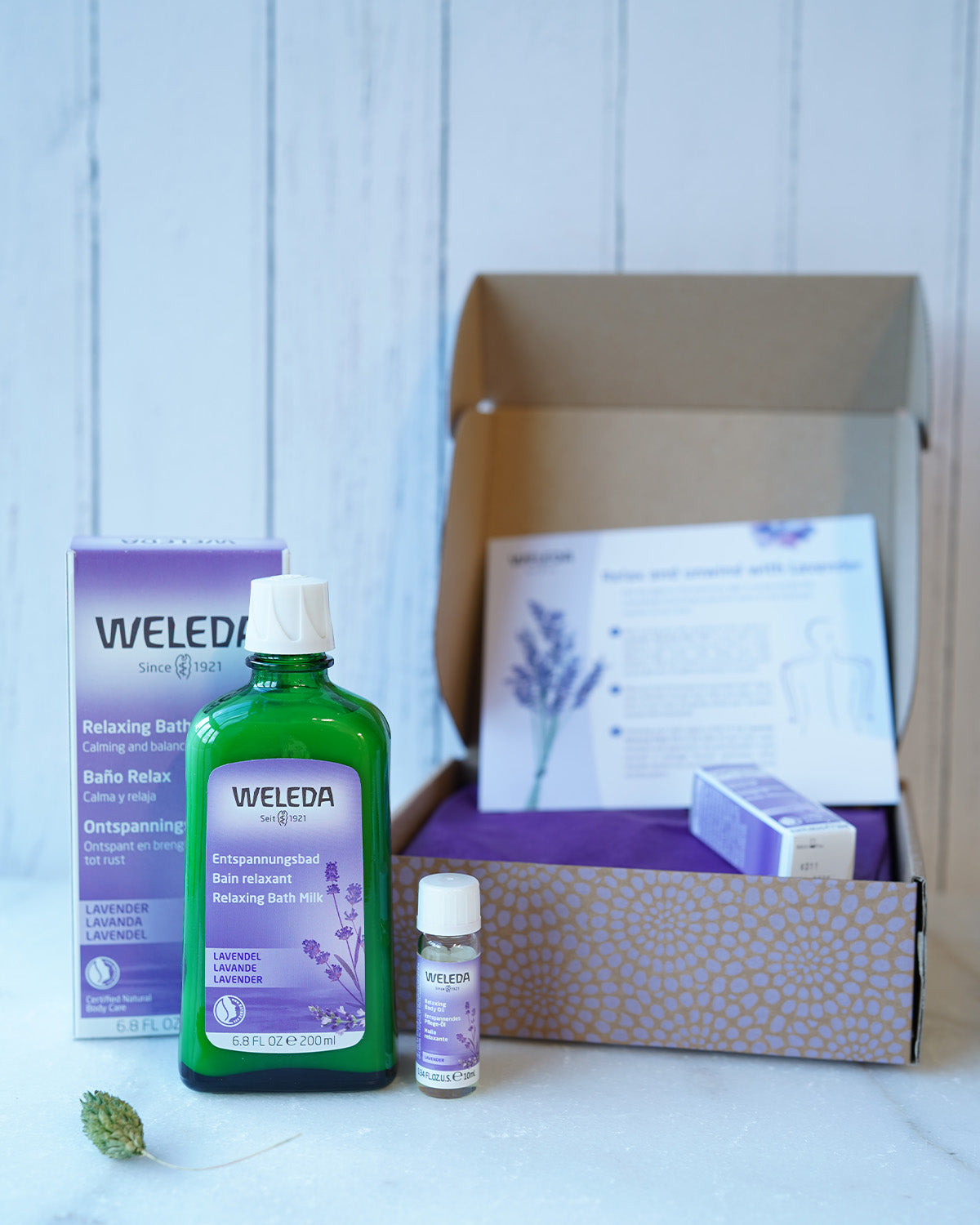 Weleda Relax & Unwind Wellbeing Gift Set - Lavender.  This luxurious lavender gift set includes Lavender Relaxing Bath Milk 200ml and a mini Lavender Relaxing Body Oil 10ml. Also pictured is the eco friendly and decorated cardboard box packaging and a sel