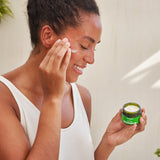 A close up photo of a person washing their face with the Weleda Nourishing face balm