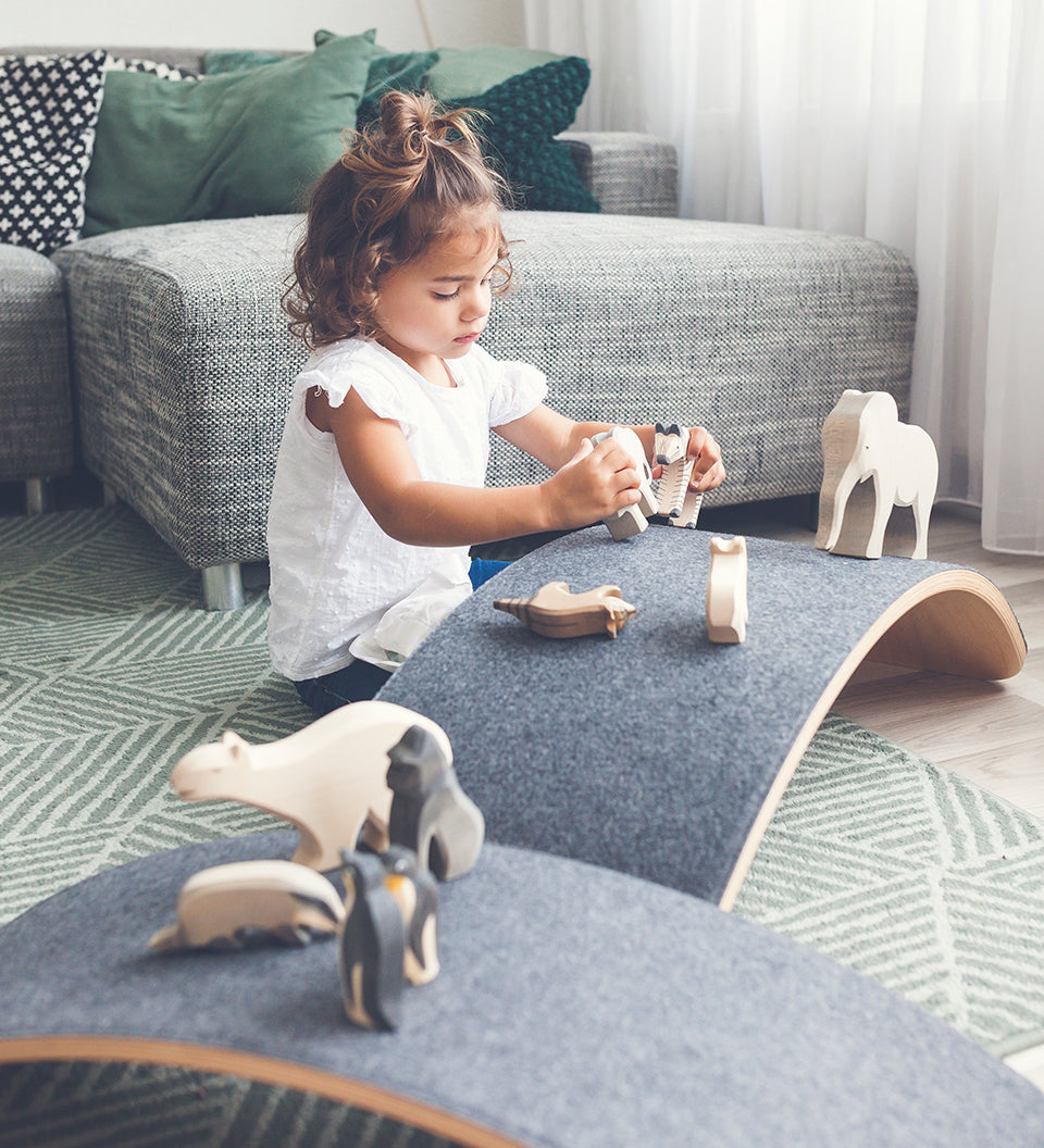 Girl playing with wooden toys on a Wobbel Pro Felt balance board