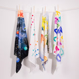 4 organic cotton childrens Wonder Cloths hanging from a rope line on a white background