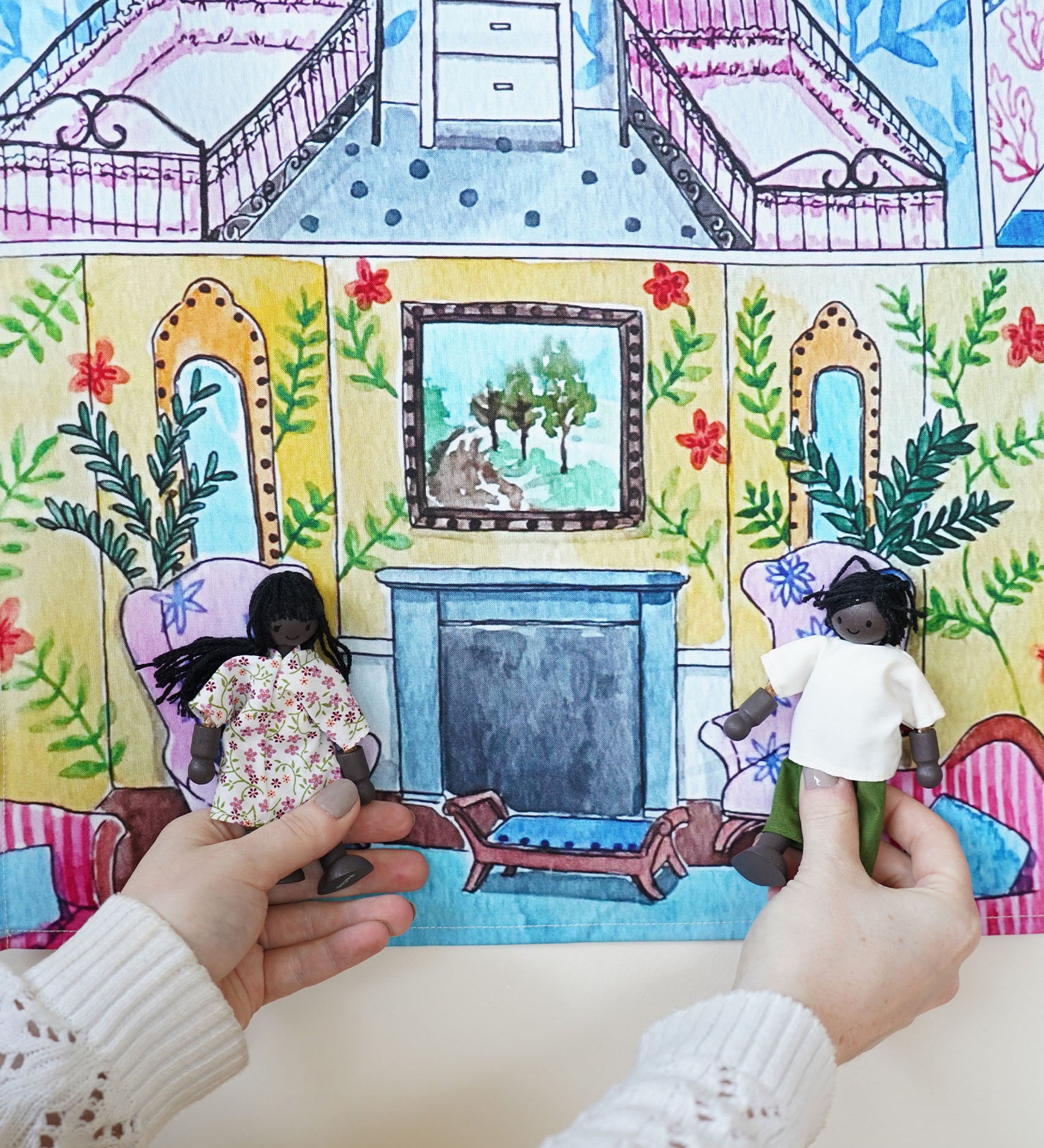 Two dolls sitting on the printed chairs in the Wonderie Sensory Play Cloth - Welcome To The Doll House.