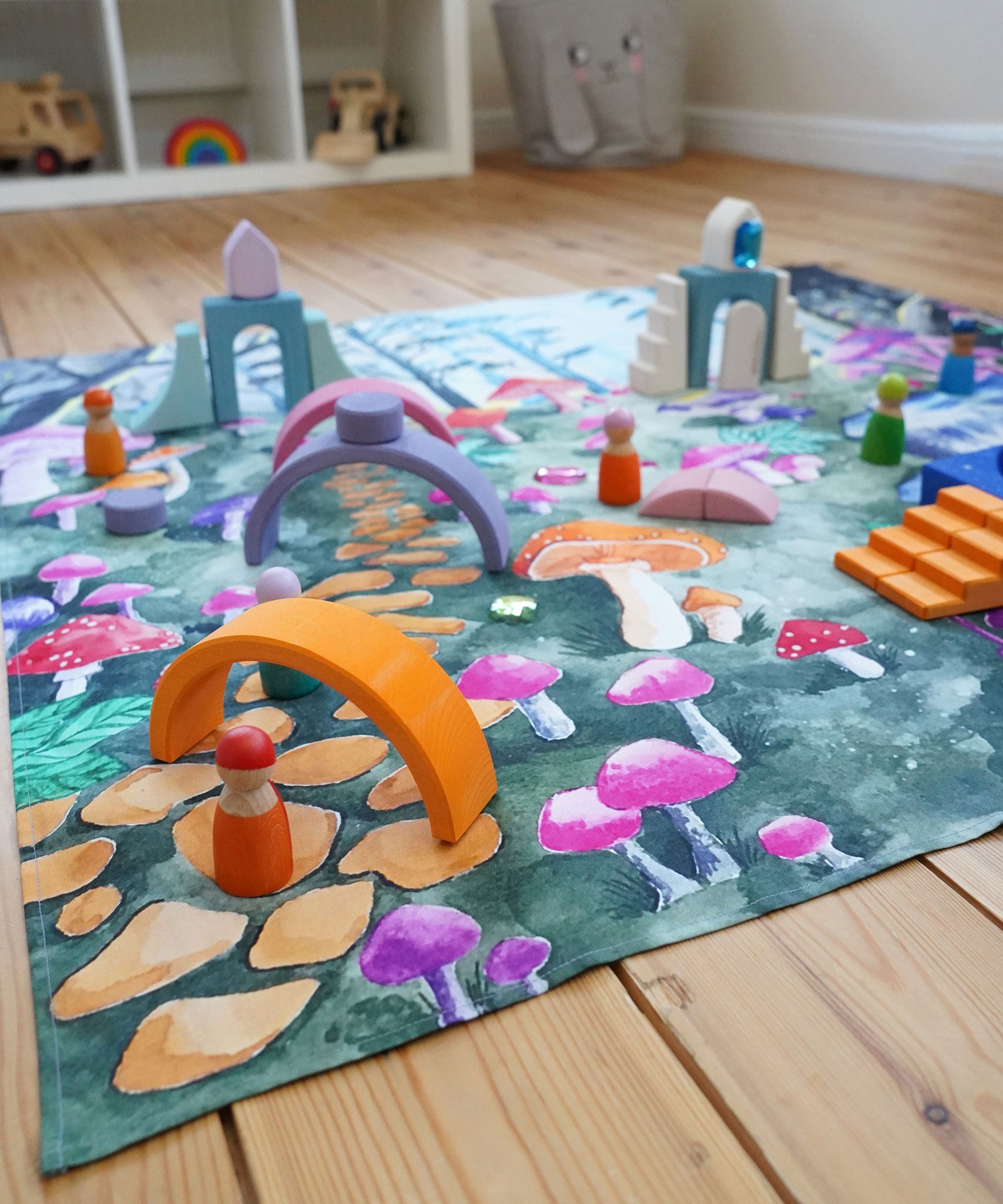 Wonderie Play Cloth with a Enchanted Toadstool Forest design in a play room covered in wooden toys and peg dolls.