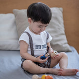 A child happily playing with the PlanToys Wooden Nuts and Bolts Puzzle.