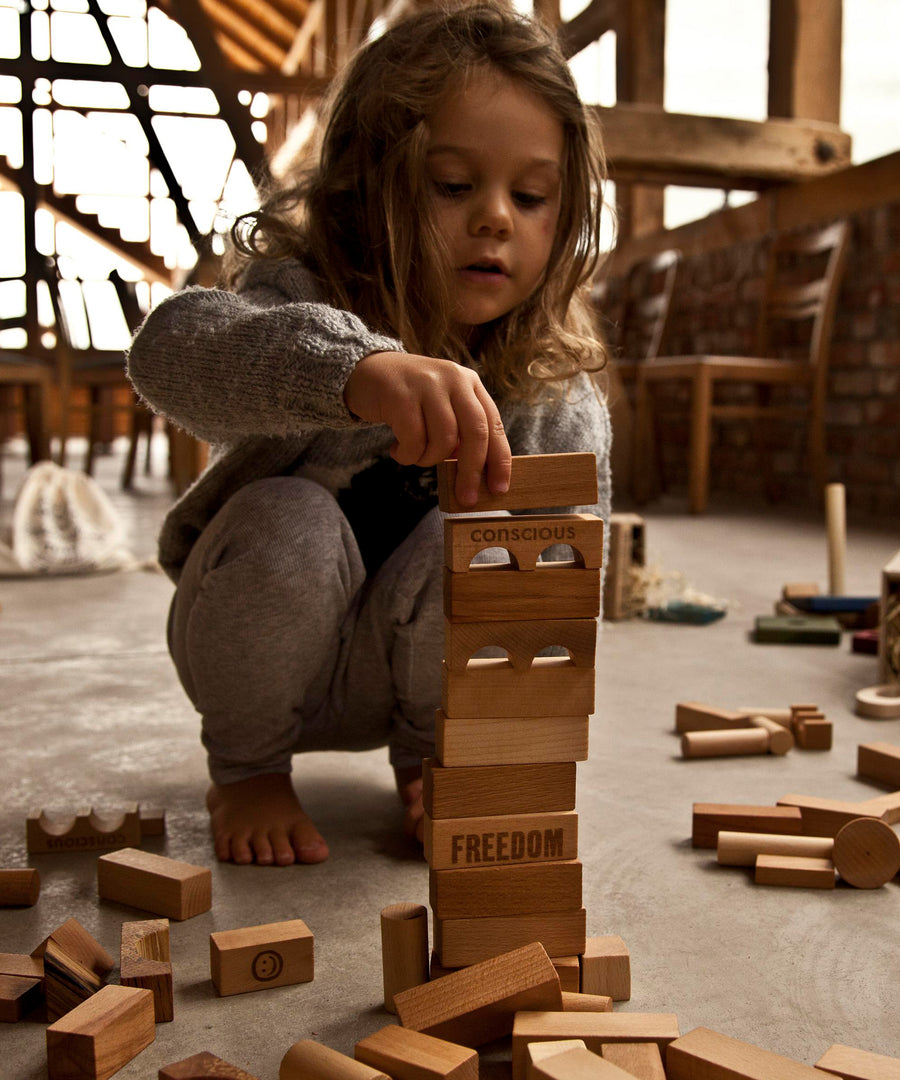 A child stacking natural Wooden Story blocks.