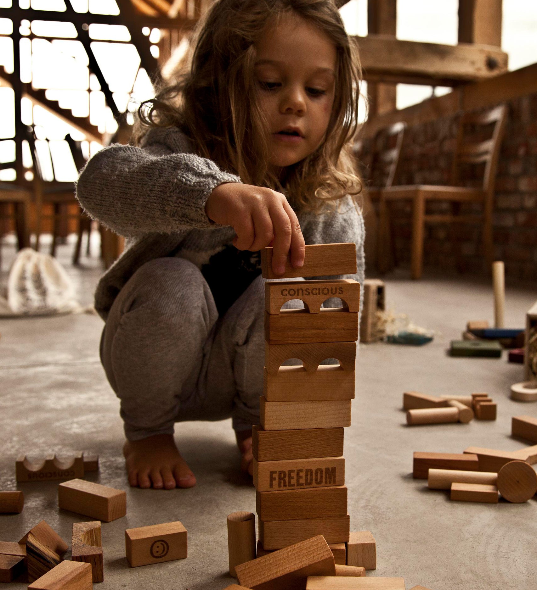 A child stacking natural Wooden Story blocks.