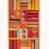 Wooden Story 54 Warm Blocks in Tray on a plain background. The set features various shapes of wooden clocks in warm orange, natural and yellow shades. 